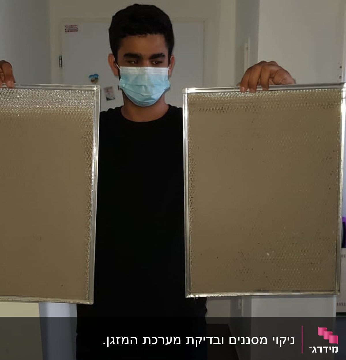 אדם מחזיק שני מסנני אוויר למזגן